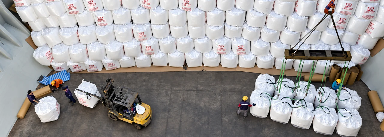Super sacks being handled in the cargo hold using a lifting beam and forklift.